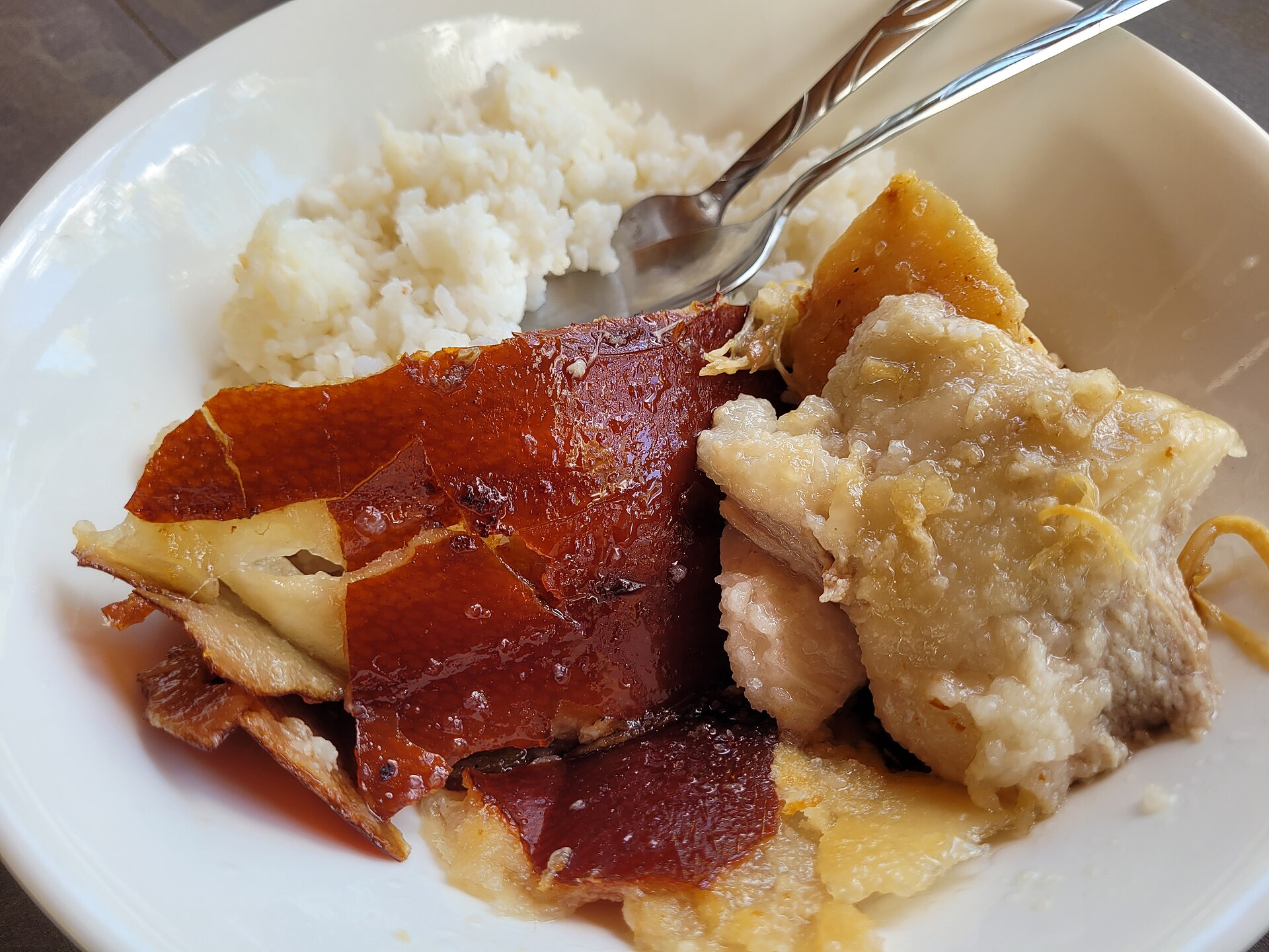 A plate of lechon: crackling roast pork skin and meat served with rice
